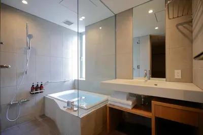 a bathroom with a tub and a sink and a shower at Kaminarimon Ryokan in Tokyo