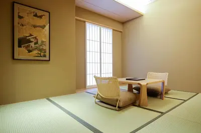a room with a table and chairs and a window at Kaminarimon Ryokan in Tokyo