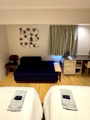 a living room with two beds and a couch at EN Hotel Shibuya in Tokyo