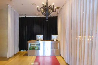 a lobby with a chandelier and a table with curtains at EN Hotel Shibuya in Tokyo
