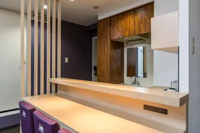 a kitchen with a wooden counter and purple chairs at HOTEL MYSTAYS Asakusa in Tokyo