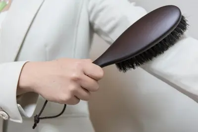 a person holding a brush in their hand at HOTEL MYSTAYS Asakusa in Tokyo