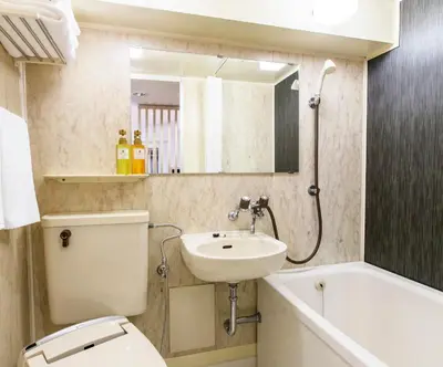 a bathroom with a toilet and a sink and a bath tub at HOTEL MYSTAYS Asakusa in Tokyo