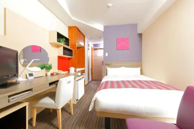 a hotel room with a bed and a desk with a computer at HOTEL MYSTAYS Asakusa in Tokyo