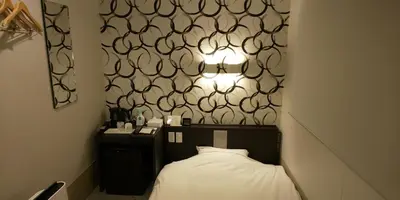 a bedroom with a bed and a black and white wall at Ueno First City Hotel in Tokyo