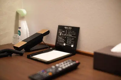 a desk with a tablet and two remote controls at Ueno First City Hotel in Tokyo