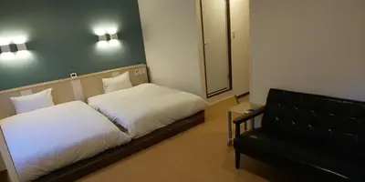 a bedroom with a bed and a mirror and a chair at Ueno First City Hotel in Tokyo