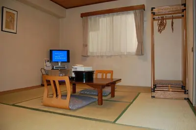 a room with a desk with a computer and chairs at Hotel Tateshina in Tokyo
