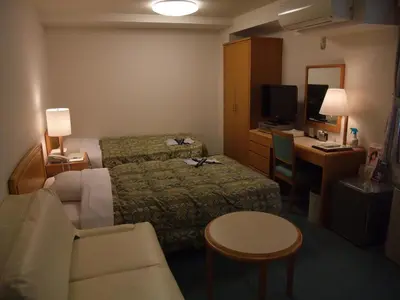 a hotel room with a bed and a desk and a television at Hotel Tateshina in Tokyo