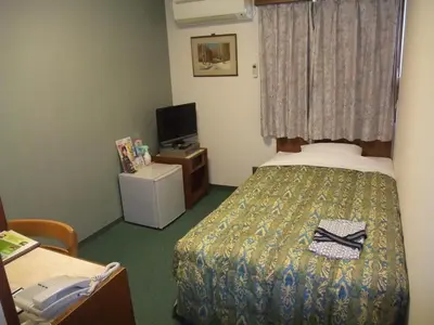 a hotel room with a bed with a pair of shoes on it at Hotel Tateshina in Tokyo