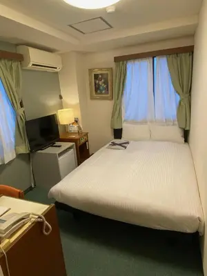 a bedroom with a large bed and a television at Hotel Tateshina in Tokyo