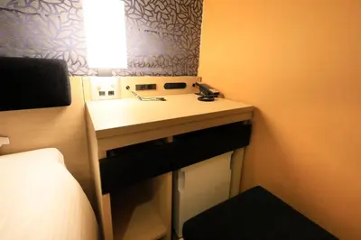 a small bathroom with a sink and a bed at Hotel Nihonbashi Saibo in Tokyo