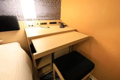 a small bathroom with a sink and a bed at Hotel Nihonbashi Saibo in Tokyo