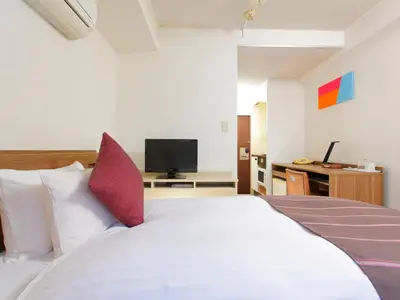 a bedroom with a white bed and a television at HOTEL MYSTAYS Ueno Iriyaguchi in Tokyo