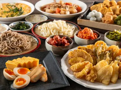 a table with plates of food and bowls of food at HOTEL MYSTAYS Ueno Iriyaguchi in Tokyo