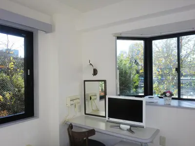 a computer monitor on a desk in a room with windows at Hotel Park Avenue in Tokyo