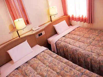 a hotel room with two beds and a phone at Hotel Park Avenue in Tokyo