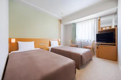 a hotel room with two beds and a television at Candeo Hotels Ueno Park in Tokyo