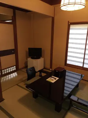 a living room with a table and a tv at Hotel Edoya in Tokyo