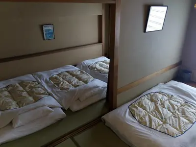 two beds in a room with white blankets at Hotel Edoya in Tokyo