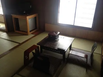 a room with a table and chairs and a tv at Hotel Edoya in Tokyo