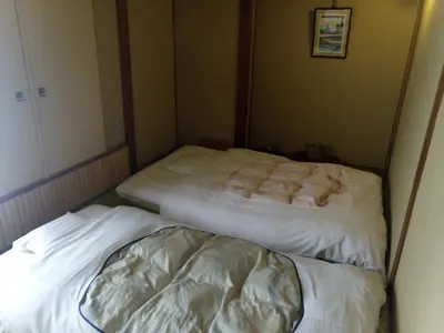 two beds in a small room with white sheets at Hotel Edoya in Tokyo