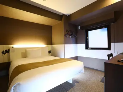 a bedroom with a large bed and a window at KOKO HOTEL Ueno Station - formerly Hotel Wing International Select Ueno Okachimachi in Tokyo