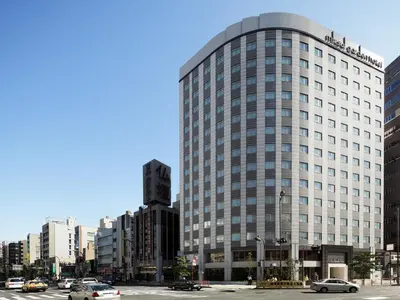a tall building with cars parked in a city at Mitsui Garden Hotel Ueno in Tokyo