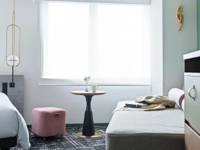 a bedroom with a bed and a table and a window at Mitsui Garden Hotel Ueno in Tokyo