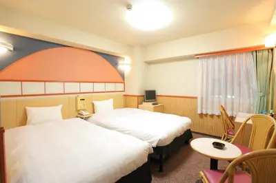 a hotel room with two beds and a table at Hotel Marutani in Tokyo