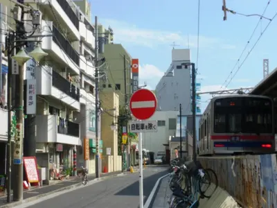 a red stop sign on a street with a bus at Sky Heart Hotel Koiwa in Tokyo