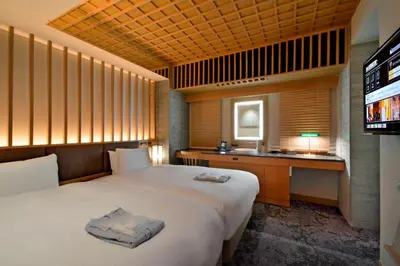 a hotel room with a bed and a television at HOTEL HILLARYS Akasaka in Tokyo