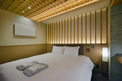 a bedroom with a white bed with towels on it at HOTEL HILLARYS Akasaka in Tokyo