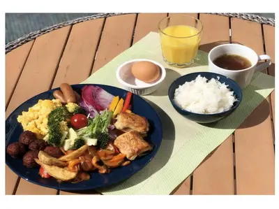 a table with two plates of food with rice and a drink at HOTEL HILLARYS Akasaka in Tokyo