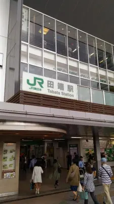 a group of people walking outside of a building at Base Inn Tabata in Tokyo