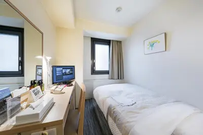 a bedroom with a bed and a desk with a computer at Ginza Capital Hotel Akane in Tokyo