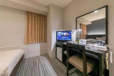 a hotel room with a desk with a computer and a mirror at Ginza Capital Hotel Akane in Tokyo