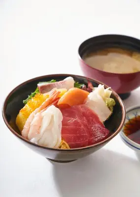 a bowl filled with different types of food on a table at Ginza Capital Hotel Akane in Tokyo
