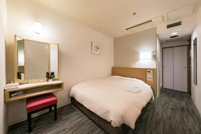 a hotel room with a bed and a mirror at Ginza Capital Hotel Akane in Tokyo