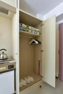 a kitchen with a closet with white towels and a stove at Refre Forum in Tokyo
