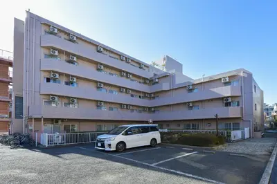 a white car parked in a parking lot in front of a building at Refre Forum in Tokyo