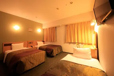 a hotel room with two beds and a window at Hotel Grand City in Tokyo