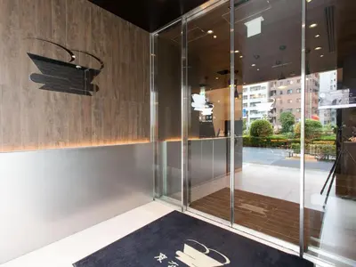 a room with a glass door with shoes on the floor at Henn na Hotel Tokyo Ginza in Tokyo