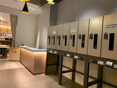 a room with a row of lockers with cell phones at Henn na Hotel Tokyo Ginza in Tokyo