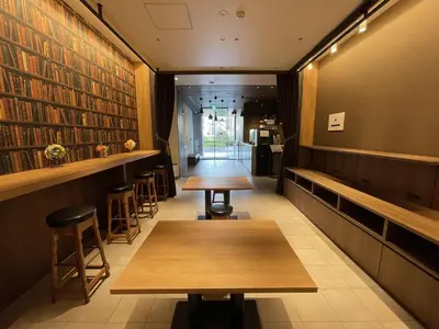 a bar with wooden tables and stools in a restaurant at Henn na Hotel Tokyo Ginza in Tokyo