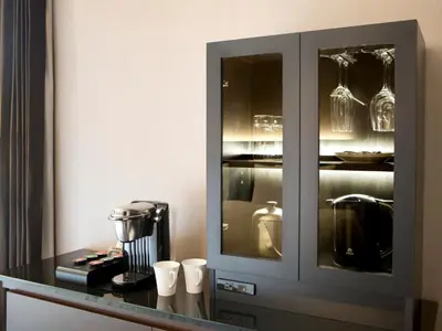 a kitchen with a cabinet with cups on a counter at The Royal Park Hotel Iconic Tokyo Shiodome in Tokyo
