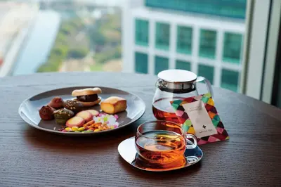 a table with a plate of food and a bottle of tea at The Royal Park Hotel Iconic Tokyo Shiodome in Tokyo