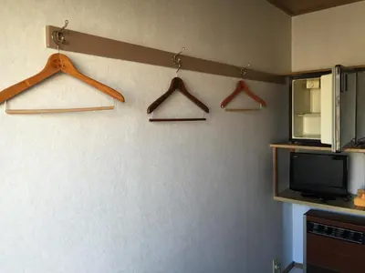 a room with hangers and a tv on a wall at Asakusa Hotel Fukudaya in Tokyo