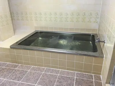 a bath tub in a tiled bathroom at Asakusa Hotel Fukudaya in Tokyo
