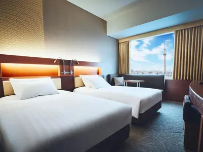 a hotel room with two beds and a window at Lotte City Hotel Kinshicho in Tokyo